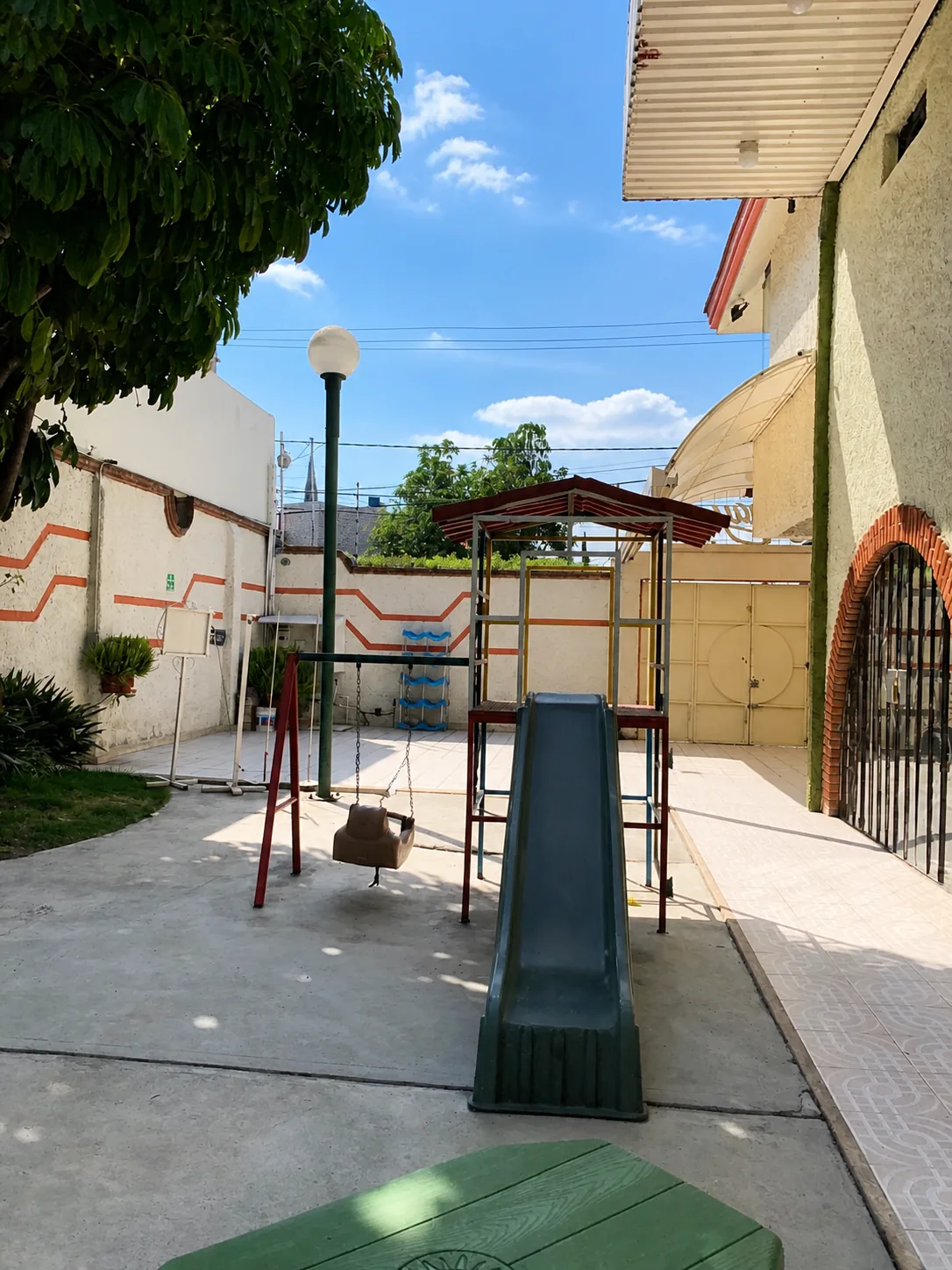 Acceso exterior del Salón Arnay con portón y área de juegos