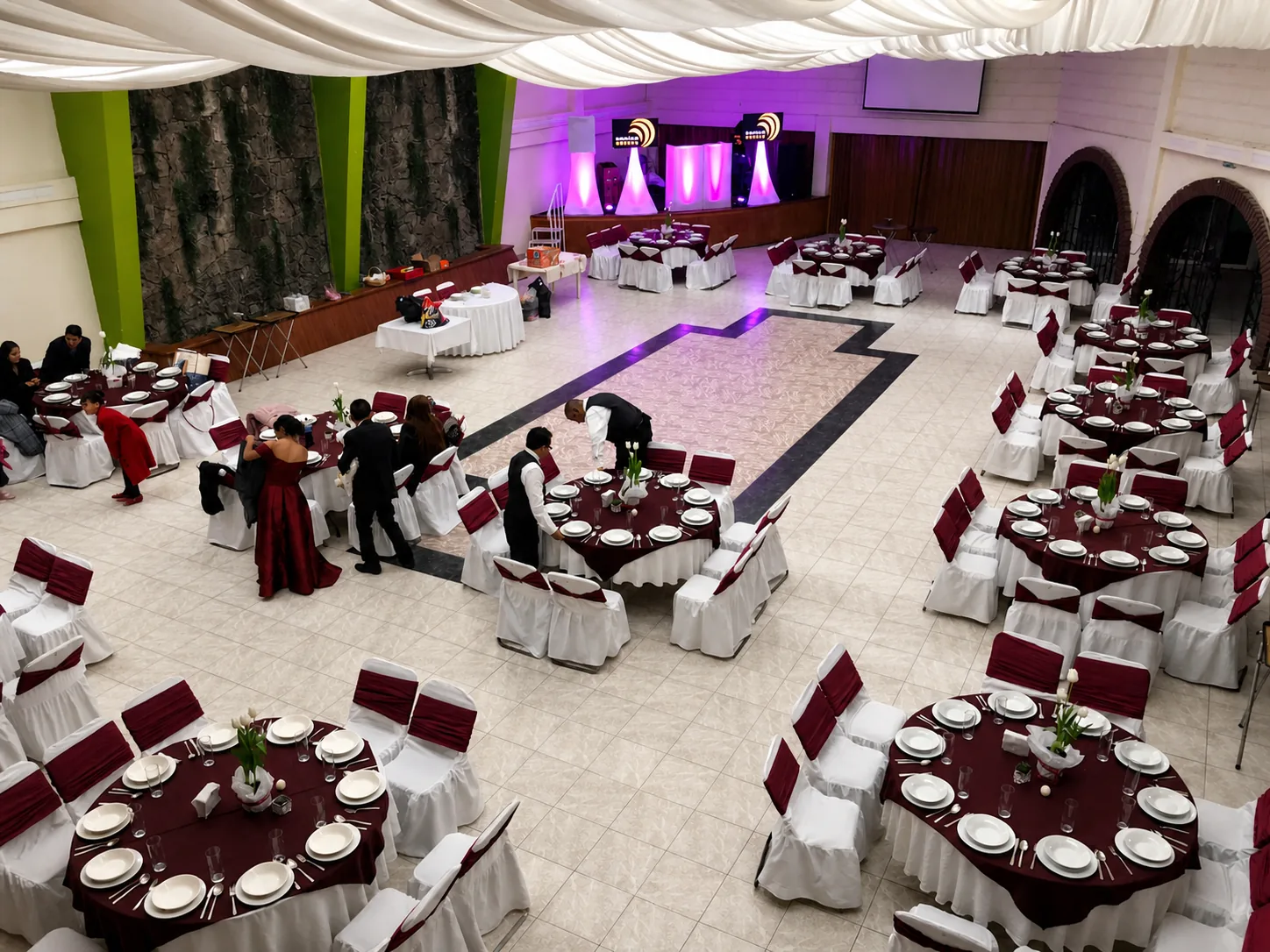 Salón Arnay con pista central y mesas vestidas en tonos vino